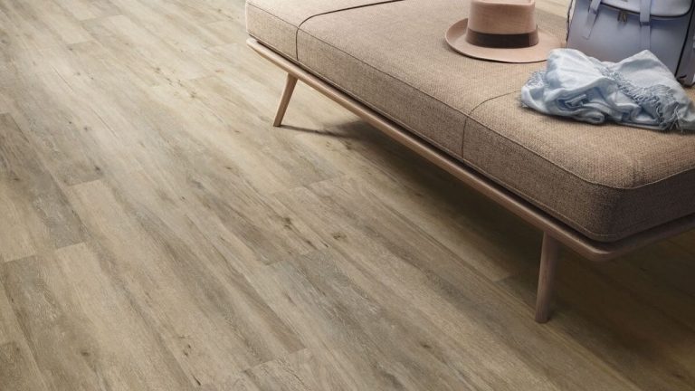 a living room floor close up picture with a beige color wood looking tile